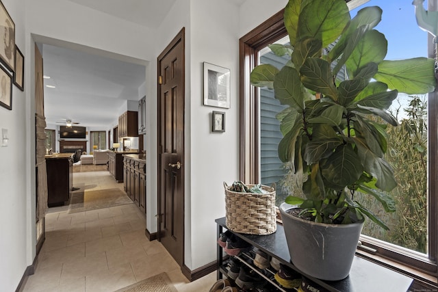 corridor with light tile patterned floors and baseboards