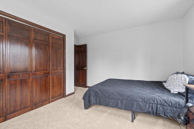 bedroom featuring light colored carpet and a closet