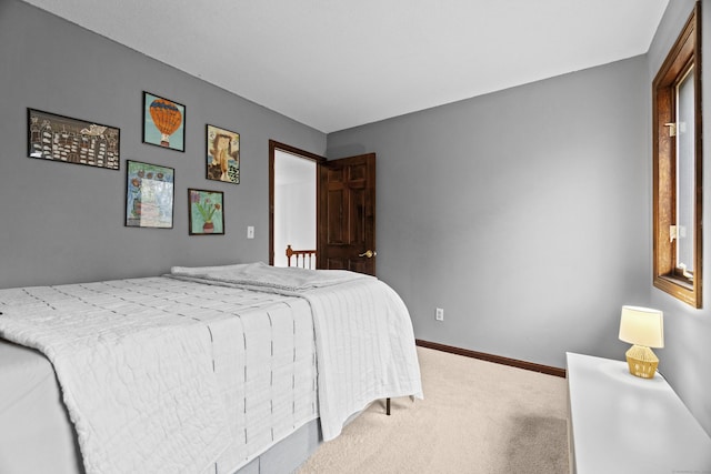 bedroom featuring baseboards and light carpet