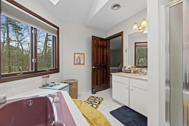 full bath with a garden tub, a healthy amount of sunlight, tile patterned flooring, and vanity