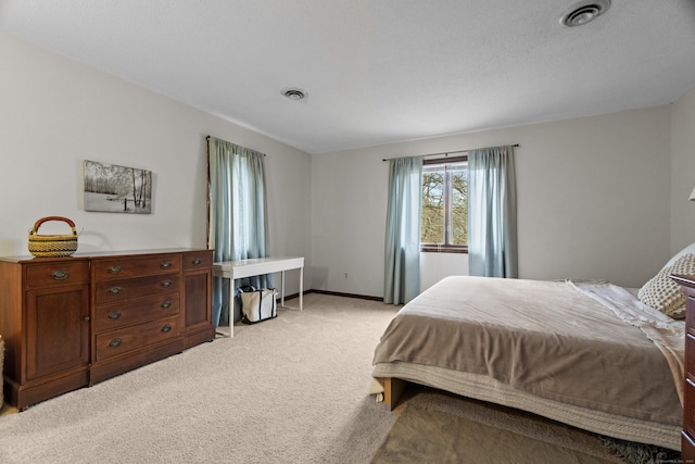 bedroom with baseboards, light colored carpet, and visible vents