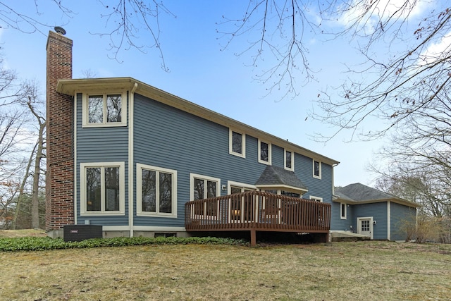 rear view of property featuring a lawn, central AC, a wooden deck, and a chimney