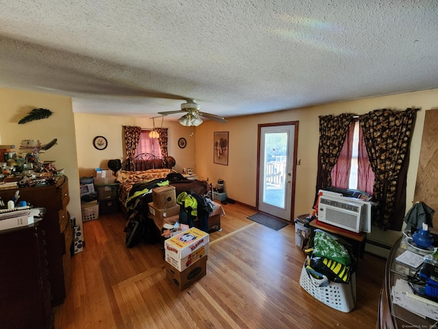27 Payne Pl, Meriden, CT 06450 - living room featuring wood finished floors, a textured ceiling, a baseboard radiator, a wall unit AC, and a ceiling fan