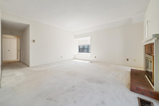 917 Heritage Vlg Unit B, Southbury, CT 06488 - unfurnished living room featuring a brick fireplace and light carpet