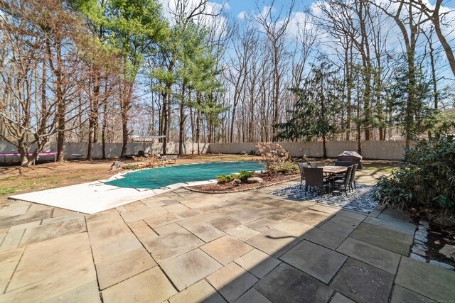 view of pool featuring a fenced backyard, a fenced in pool, outdoor dining space, and a patio