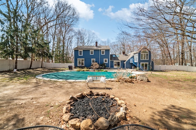back of property with a fenced backyard, a chimney, a patio area, and a fenced in pool