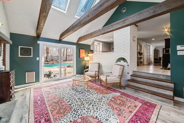 living area featuring high vaulted ceiling, baseboards, beam ceiling, a skylight, and wood finished floors