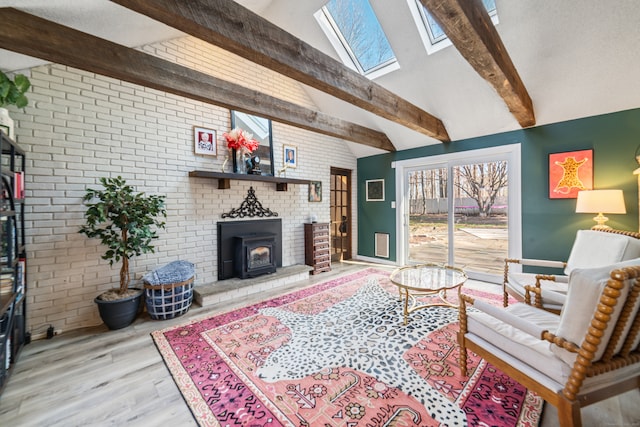 living area with brick wall, vaulted ceiling with skylight, and wood finished floors