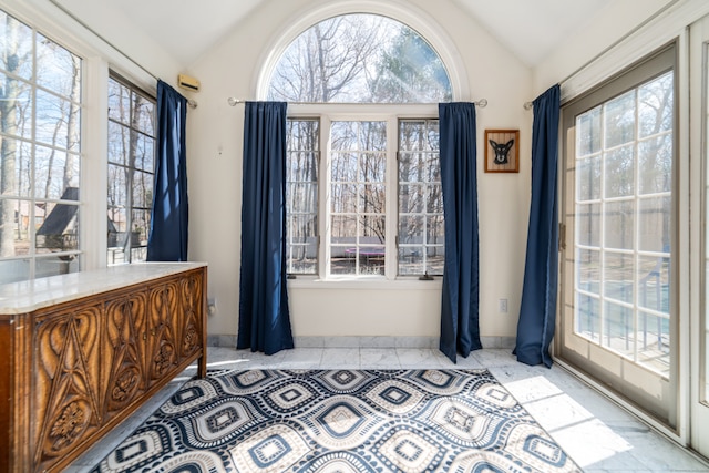 dining space featuring baseboards, vaulted ceiling, and light tile patterned floors