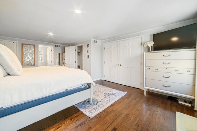 bedroom featuring a closet, dark wood-style flooring, and visible vents