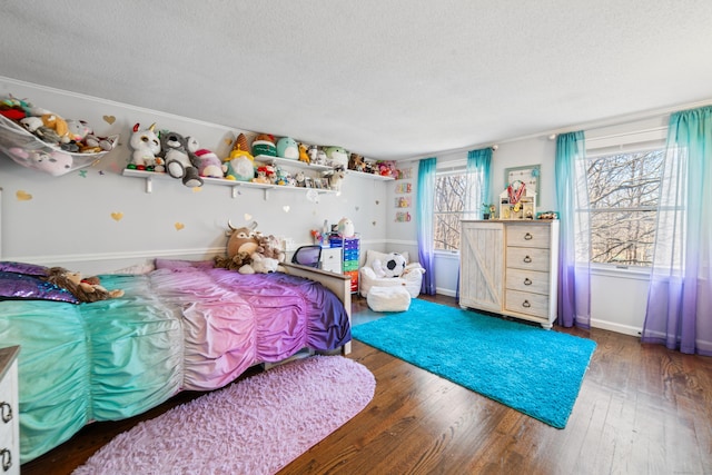 bedroom featuring baseboards, a textured ceiling, and wood-type flooring