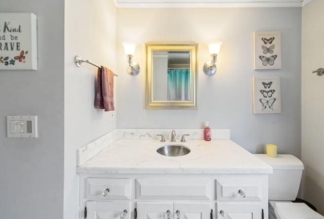 full bathroom with toilet, ornamental molding, and vanity