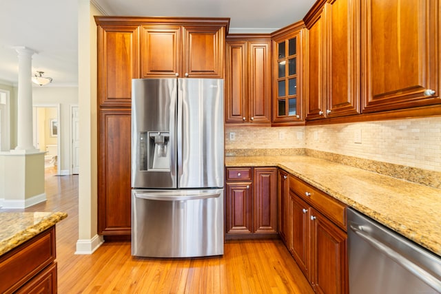 1 Winding Trl Unit 1, Middlebury, CT 06762 - kitchen with stainless steel appliances, decorative columns, light wood-style floors, tasteful backsplash, and light stone counters