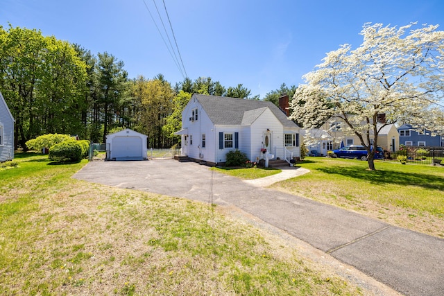 bungalow featuring an outdoor structure, a front lawn, driveway, and a detached garage