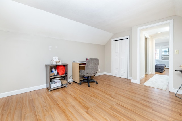 office area with baseboards, cooling unit, vaulted ceiling, and light wood finished floors