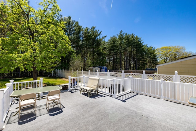 view of patio / terrace featuring a fenced backyard, an outbuilding, a storage shed, and outdoor dining space