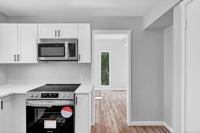 433 Heritage Vlg Unit A, Southbury, CT 06488 - kitchen featuring light wood-style flooring, white cabinets, and stainless steel appliances