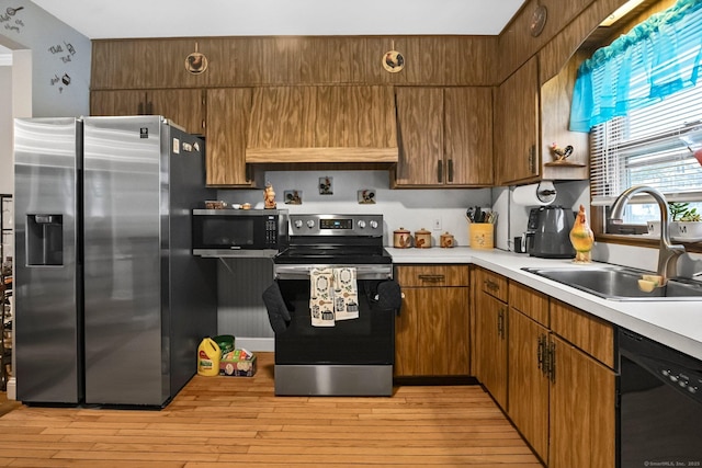 17 Winfield Dr, Stratford, CT 06615 - kitchen with stainless steel appliances, a sink, light countertops, and light wood-type flooring