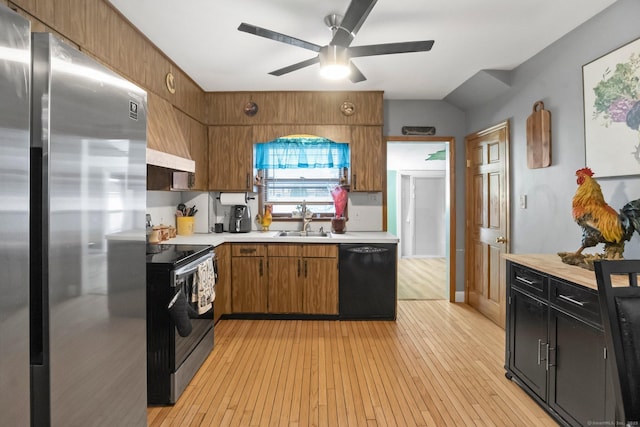 kitchen featuring stainless steel appliances, light countertops, light wood-type flooring, a ceiling fan, and a sink
