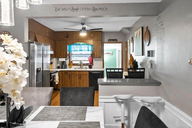 kitchen featuring dishwasher, stainless steel fridge with ice dispenser, light countertops, range with electric cooktop, and brown cabinets