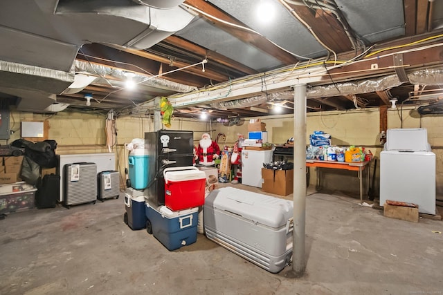 unfinished below grade area with washing machine and clothes dryer, refrigerator, and electric panel