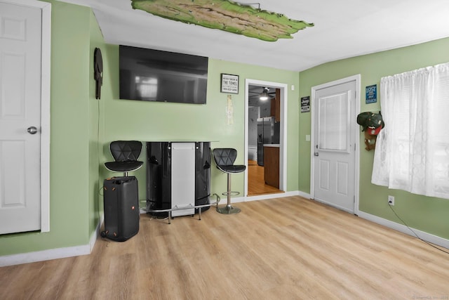 living room featuring baseboards, wood finished floors, and ceiling fan