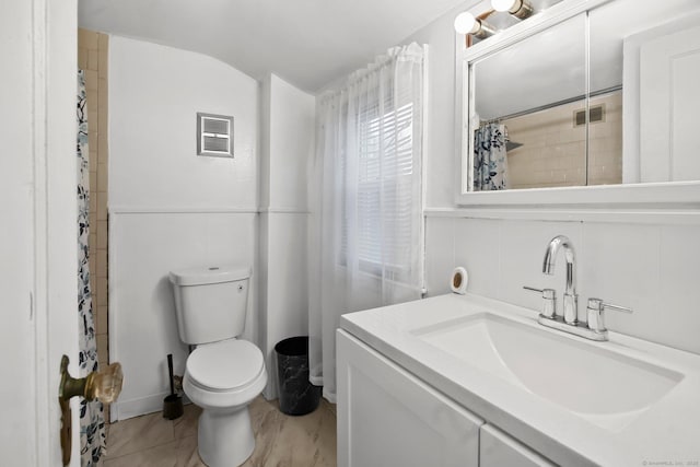 bathroom with toilet, vanity, lofted ceiling, and a shower with curtain