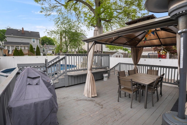 deck featuring a gazebo, a fenced backyard, and outdoor dining space
