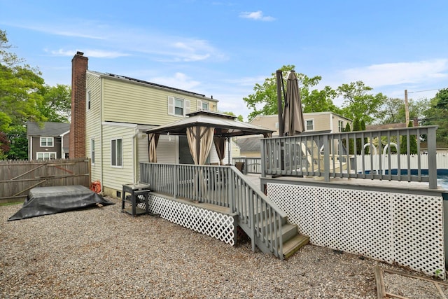 back of property with a gazebo, fence, and a deck