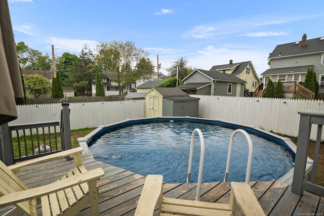 view of pool with a storage unit, a fenced backyard, an outdoor structure, and a residential view