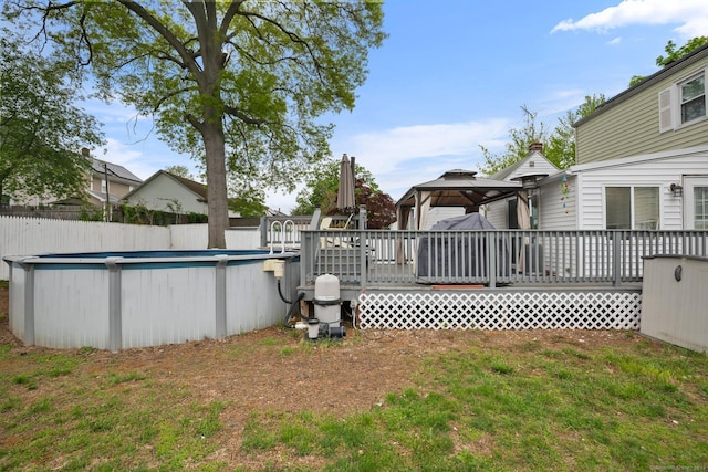 view of pool featuring a gazebo, a wooden deck, and fence