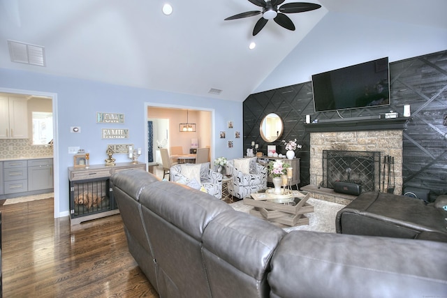 living room featuring dark wood-style flooring, ceiling fan, visible vents, and high vaulted ceiling