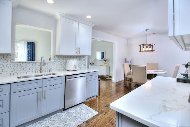 kitchen with stainless steel dishwasher, a sink, decorative backsplash, and dark wood-style floors