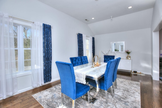 dining room with a healthy amount of sunlight, vaulted ceiling, and wood finished floors