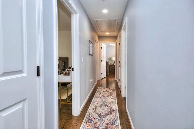 hall with baseboards, attic access, recessed lighting, and dark wood-type flooring