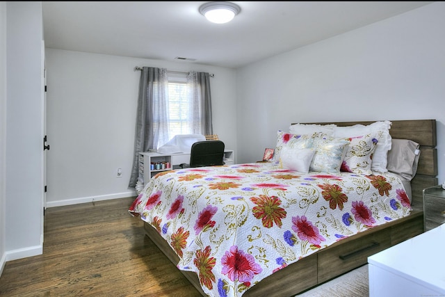 bedroom featuring baseboards, wood finished floors, and visible vents