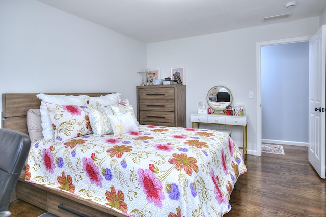 bedroom featuring baseboards, wood finished floors, and visible vents