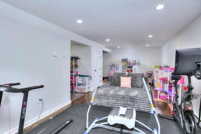 workout room with recessed lighting, baseboards, and wood finished floors