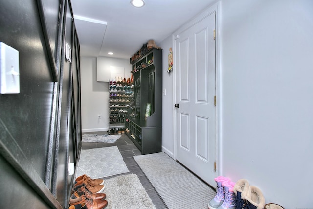interior space featuring recessed lighting, baseboards, and dark tile patterned floors