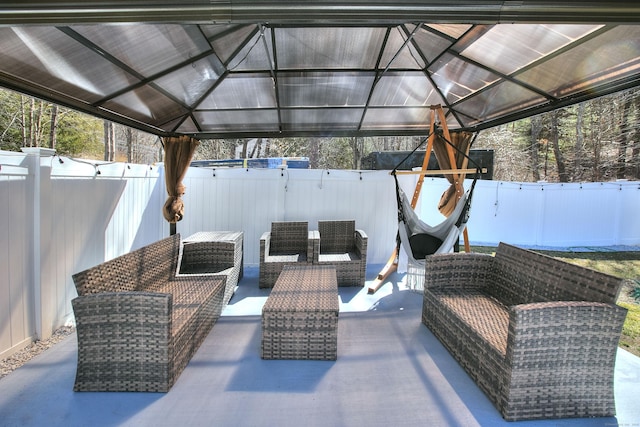 view of patio featuring an outdoor living space, a fenced backyard, and a gazebo