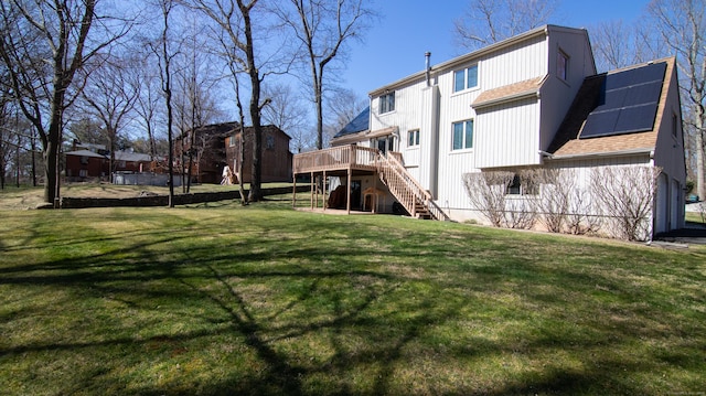 955 Dunbar Hill Rd, Hamden, CT 06514 - back of house featuring stairs, a wooden deck, solar panels, roof with shingles, and a lawn
