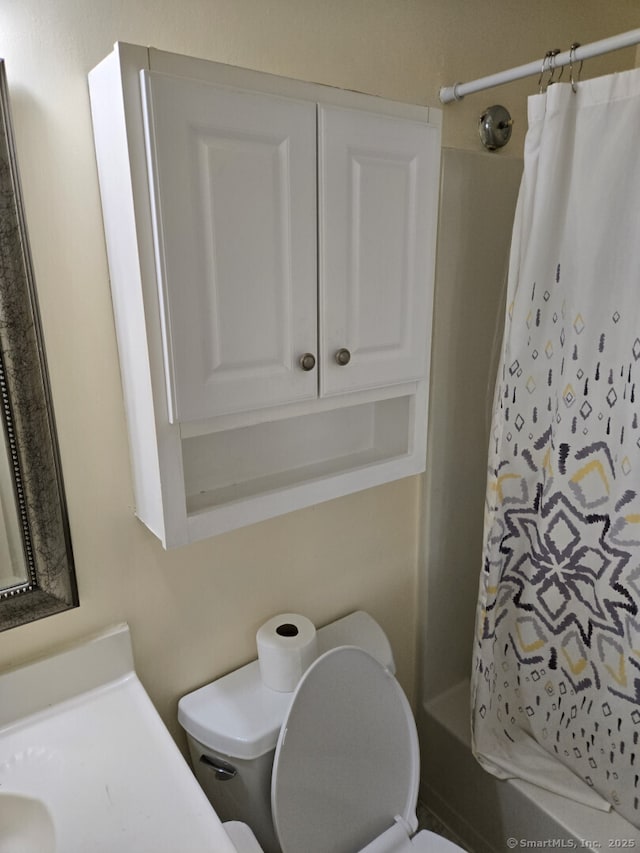 bathroom featuring toilet and a shower with curtain