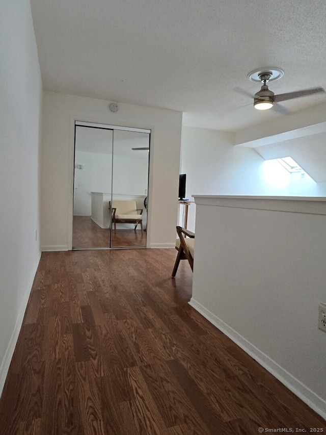 hall featuring baseboards and dark wood-type flooring