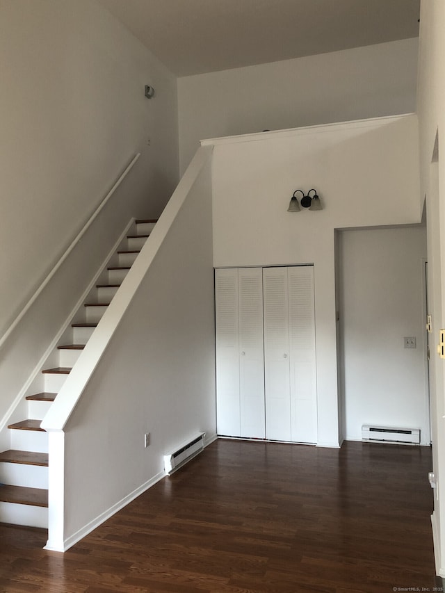 stairway with a baseboard radiator and wood finished floors
