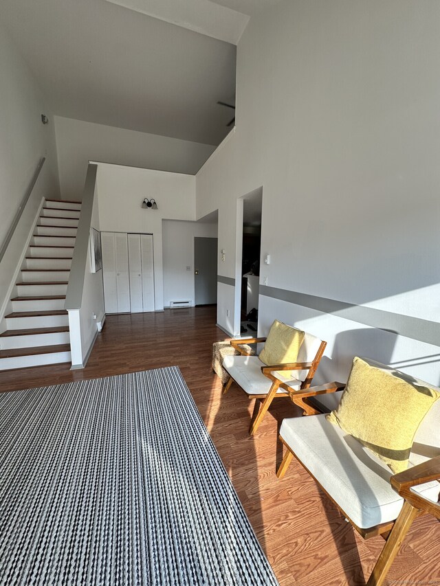 3699 Broadbridge Ave Unit 330, Stratford, CT 06614 - sitting room with high vaulted ceiling, stairway, wood finished floors, and a baseboard radiator