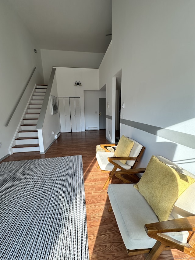 3699 Broadbridge Ave Unit 330, Stratford, CT 06614 - living area with high vaulted ceiling, wood finished floors, stairway, and a baseboard heating unit