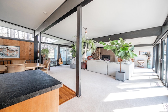interior space with expansive windows, beam ceiling, and a fireplace
