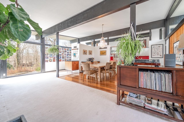 kitchen featuring carpet floors, wood finished floors, beam ceiling, and a chandelier