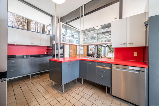 kitchen featuring a sink, white cabinetry, dishwasher, a peninsula, and oven