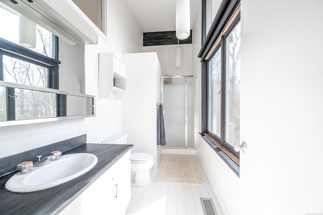 bathroom with visible vents, a shower with shower door, toilet, vanity, and tile patterned flooring